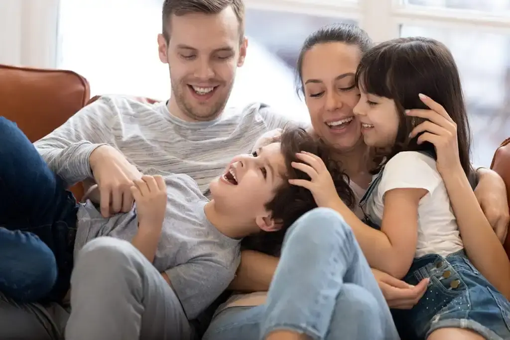 Couple playing with their children, emphasizing the importance of family planning and registering wills with a reliable Register of Wills service